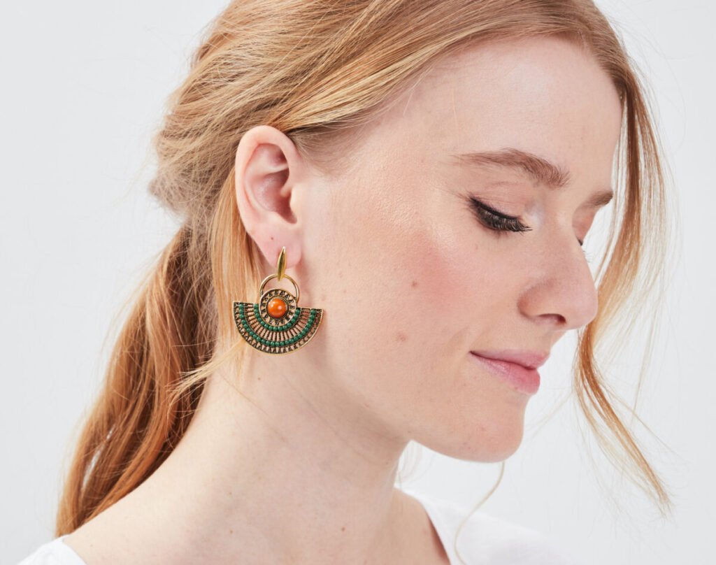 Femme qui porte une paire de boucles d'oreilles pendantes de type ancien
