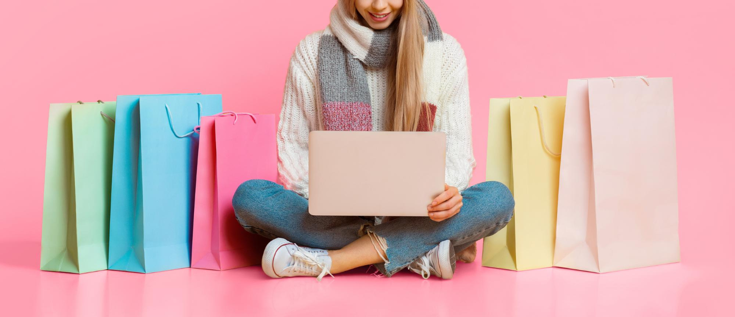 Une photo coupée d'une fille assise sur le sol tenant un ordinateur portable et faisant du shopping en ligne